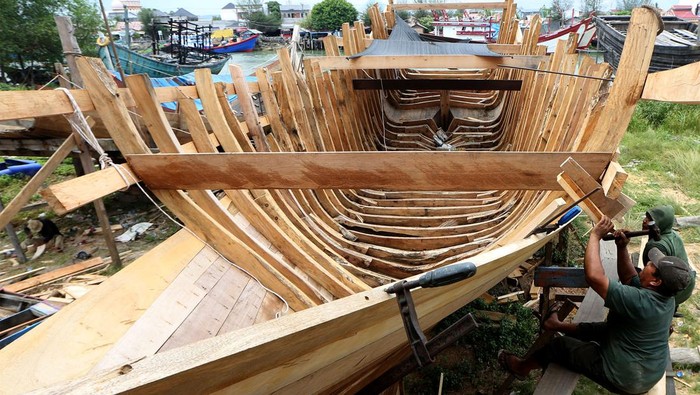 Pekerja menyelesaikan pembuatan kapal untuk kebutuhan nelayan di galangan tradisional kapal kayu, Banda Aceh, Aceh, Senin (29/5/2023). Pelaku industri galangan kapal kayu berharap adanya regulasi khusus terhadap proses perbaikan dan pembuatan baru kapal kayu untuk nelayan yang masih terkendala bahan baku kayu sejak berlakunya moratorium logging (jeda tebang) yang dikeluarkan Pemerintah Aceh pada pertengahan 2007. ANTARA FOTO/Irwansyah Putra/foc.