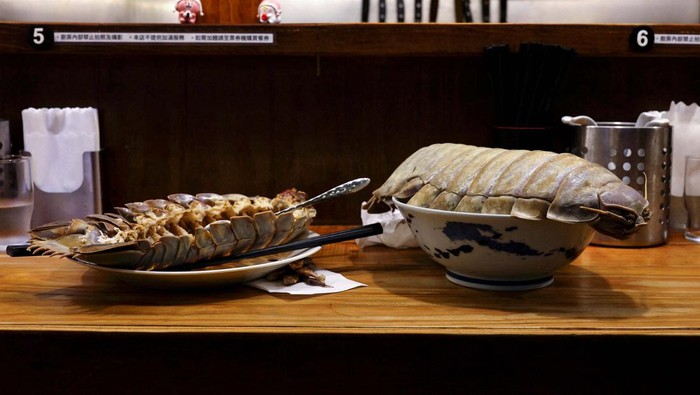 Restoran ini Sajikan Ramen dengan Topping 'Kecoa' Raksasa General Kiang, 28, one of the two reserved customers eats the giant isopod in Taipei, Taiwan May 27, 2023. REUTERS/Ann Wang