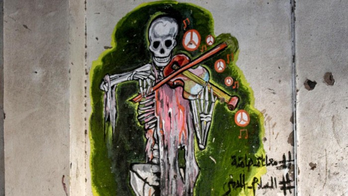 TOPSHOT - In this picture taken on May 10, 2023, Yemeni street artist Alaa Rubil finishes one of his artworks painted on a wall in the southern port city of Aden. Rubil uses the shell-pocked buildings of his hometown as canvas, painting images of death and despair to shine a light on the horrors and victims of war. Not long after the start of the bloody war between Yemen's internationally recognised government and Huthi rebel forces, the 30-year-old artist's home of Aden became the scene of brutal fighting. (Photo by Saleh Al-OBEIDI / AFP) (Photo by SALEH AL-OBEIDI/AFP via Getty Images)