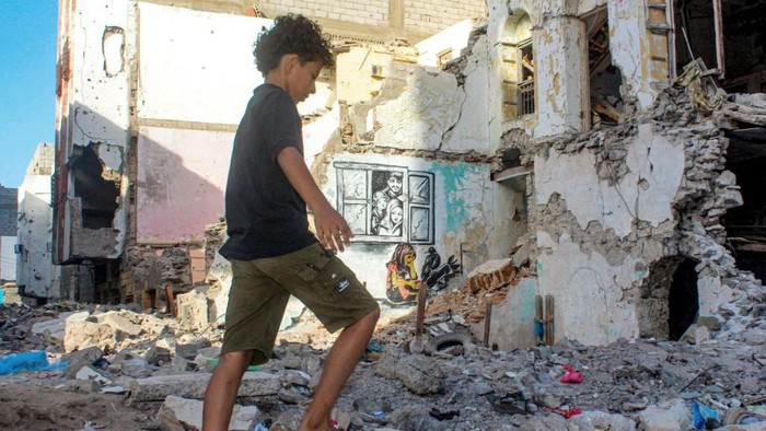 TOPSHOT - In this picture taken on May 10, 2023, Yemeni street artist Alaa Rubil finishes one of his artworks painted on a wall in the southern port city of Aden. Rubil uses the shell-pocked buildings of his hometown as canvas, painting images of death and despair to shine a light on the horrors and victims of war. Not long after the start of the bloody war between Yemen's internationally recognised government and Huthi rebel forces, the 30-year-old artist's home of Aden became the scene of brutal fighting. (Photo by Saleh Al-OBEIDI / AFP) (Photo by SALEH AL-OBEIDI/AFP via Getty Images)