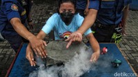Salah satu warga mencoba untuk melakukan pemadaman dengan metode menggunakan handuk yang telah dibasahi.