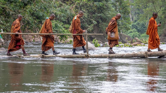 Tiba di Semarang, 32 Biksu Ikuti Ritual Thudong Sejumlah biksu yang mengikuti ritual Thudong menyeberangi Sungai Kaligarang untuk menuju ke Wihara 2500 Buddha Jayanti-Sima di Bukit Kassapa Pudakpayung, Kota Semarang, Jawa Tengah, Senin (29/5/2023). Pada hari kedua di Kota Semarang sebanyak 32 biksu yang mengikuti ritual Thudong dengan berjalan kaki dari Thailand itu mengunjungi kelenteng dan wihara untuk pembacaan doa paritta sebagai pemberkatan keselamatan dan kesejahteraan umat manusia sebelum melanjutkan perjalanan menuju Candi Borobudur dalam rangka menyambut Hari Raya Waisak pada 4 Juni mendatang. ANTARA FOTO/ Aji Styawan/foc.