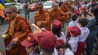 Dalam perjalanannya, sejumlah  siswa sekolah dasar memberikan bekal makanan kepada sejumlah biksu yang mengikuti ritual Thudong saat melintasi Jalan Pemuda, Kota Semarang, Jawa Tengah.