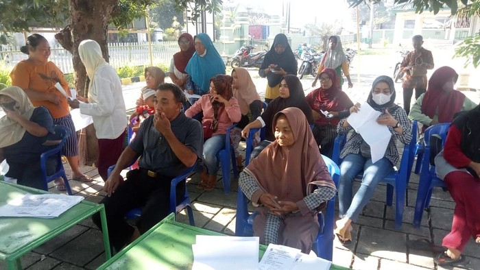Warga Desa Ngawen, Kecamatan Ngawen, Klaten mengambil bantuan di halaman sebab aula balai desa digembok, Senin (29/5/2023).