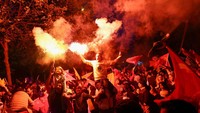 Seorang pendukung Erdogan menyalakan flare. 