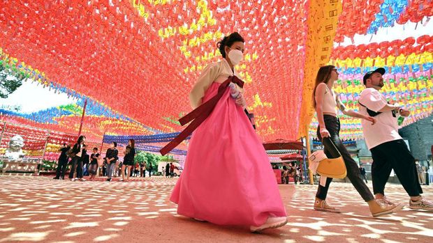 TOPSHOT - A worker attaches name cards with wishes of Buddhist followers to lotus lanterns at Jogyesa Temple in Seoul on May 26, 2023, ahead of celebrations marking Buddha's birthday on May 27. (Photo by Jung Yeon-je / AFP) (Photo by JUNG YEON-JE/AFP via Getty Images)