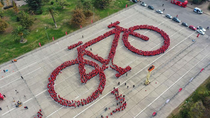 Aerial view of thousands of cyclists in the shape of a bicycle trying to break the Guinness World Record for the world's largest bicycle, in the framework of the Bicycle Festival, in Santiago on May 27, 2023. (Photo by MARTIN BERNETTI / AFP) (Photo by MARTIN BERNETTI/AFP via Getty Images)