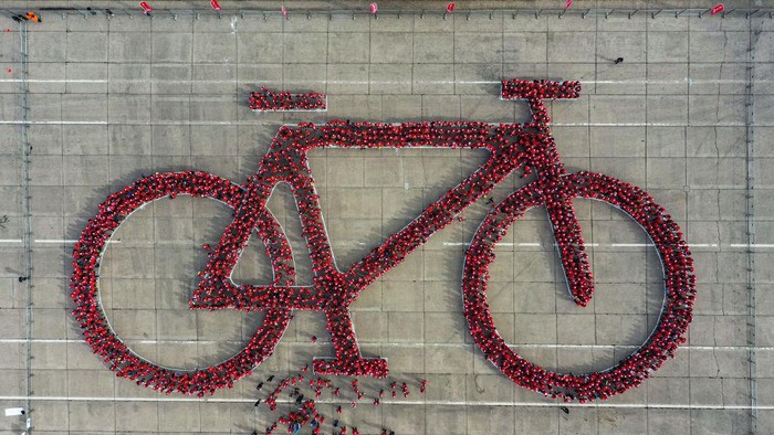 Aerial view of thousands of cyclists in the shape of a bicycle trying to break the Guinness World Record for the world's largest bicycle, in the framework of the Bicycle Festival, in Santiago on May 27, 2023. (Photo by MARTIN BERNETTI / AFP) (Photo by MARTIN BERNETTI/AFP via Getty Images)