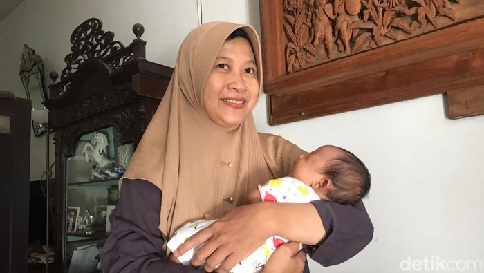 Andina Fitria Utaminingrum (42), calon jemaah haji asal Jogja bersama bayinya saat ditemui di rumahnya, Selasa (30/5/2023).