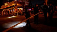 Pengamat dan petugas polisi Hollywood terlihat di dekat lokasi penembakan di Hollywood Beach Broadwalk di Hollywood, Florida, Amerika Serikat, Senin (29/5/2023).  