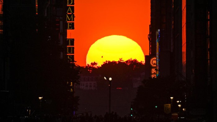 Memandang Senja dari Pusat Kota New York NEW YORK, NY - MAY 29: The sun sets along 42nd Street during a Manhattanhenge sunset on May 29, 2023, in New York City. (Photo by Gary Hershorn/Getty Images)