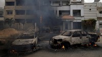 Di satu lingkungan, mobil-mobil dilalap api dan sebuah gedung kementerian dibakar.  