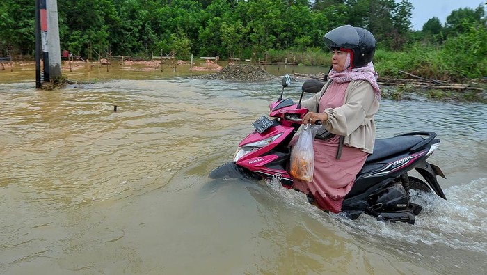 Potret Kendaraan Terobos Banjir di Jambi Sejumlah bocah bermain air di dekat kendaraan yang menerobos jalan yang terendam banjir di Kenali Asam Atas, Kota Baru, Jambi, Selasa (30/5/2023). Banjir yang terjadi akibat kurang berfungsinya sistem drainase setelah kota itu dilanda hujan deras sekitar tiga jam pada Selasa (30/5) dini hari mengakibatkan sejumlah ruas jalan terendam hingga ketinggian 60 cm. ANTARA FOTO/Wahdi Septiawan/tom.