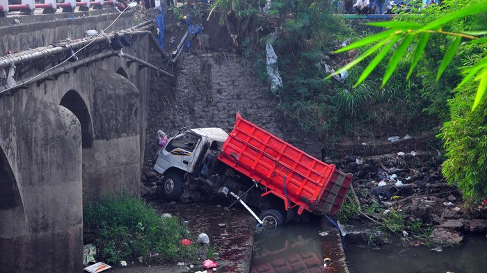 Supir Mengantuk, Truk Masuk Sungai di Kudus Warga melihat sebuah truk yang mengalami kecelakaan dan jatuh ke Sungai Logung di jalur pantura, Jekulo, Kudus, Jawa Tengah, Selasa (30/5/2023). Kecelakaan tunggal tersebut akibat pengemudi truk mengantuk sehingga menabrak pembatas jembatan dan jatuh ke sungai serta menyebabkan satu orang luka-luka. ANTARA FOTO/Yusuf Nugroho/tom.