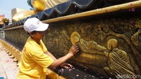 Petugas pembersih juga membersihkan relief di bawah patung Buddha tidur (Foto: Enggran Eko Budianto)