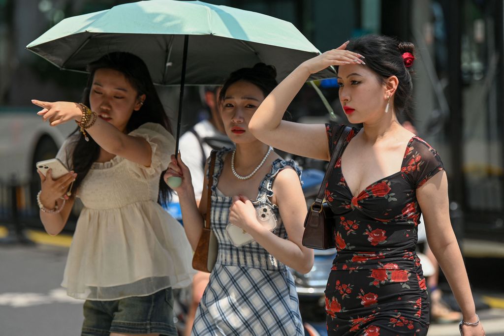 Warga beraktivitas saatb gelombang panas di Kota Shanghai, China, Senin (29/5/2023). (AFP via Getty Images)