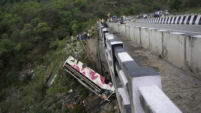A rescue operation team inspects the wreckage of a bus after an accident near Jammu, India, Tuesday, May 30, 2023. The bus carrying Hindu pilgrims to a shrine in Indian-controlled Kashmir skidded off a highway bridge into a Himalayan gorge, killing at least 10 people and injuring 55, police said. (AP Photo/Channi Anand)