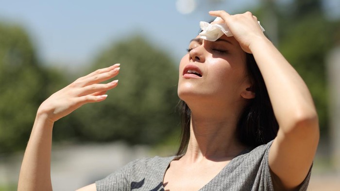 Asian woman drying sweat in a warm summer day