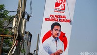 Tampak foto Kaesang berkemeja putih dan memegang bunga mawar warna merah.  