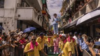 Pengunjung memadati pulau kecil Cheung Chau untuk menyaksikan anak-anak berparade dengan kostum dan makan roti yang dicap dengan karakter China untuk kedamaian dan keamanan.  