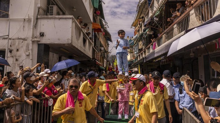 Kembalinya Fetival Bakpao di Hong Kong, Meriah Banget A child reacts as she is hoisted up during the Piu Sik Parade at the Bun Festival in Cheung Chau Island in Hong Kong, Friday, May 26, 2023. (AP Photo/Louise Delmotte)