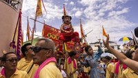 Selama pawai, anak-anak berpakaian seperti dewa legendaris atau karakter bersejarah dibawa berdiri di atas kepala orang banyak melalui jalur sempit pulau itu.  