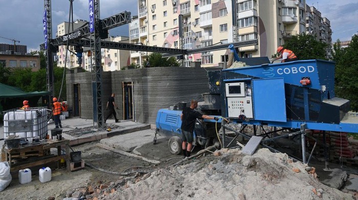 People work at a construction site of a school in Ukraine, using concrete 3D printing technology, in the western Ukrainian city of Lviv, on May 24, 2023. (Photo by YURIY DYACHYSHYN / AFP) (Photo by YURIY DYACHYSHYN/AFP via Getty Images)