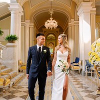 Saat akad nikah, Agustina terlihat menawan dengan tube gown berwarna putih berbelahan tinggi. Sedangkan suaminya memakai setelan serba hitam dengan aksen biru pada bagian lapel keluaran Dolce & Gabbana. Keduanya tampak serasi.Foto: Instagram