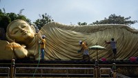 Orang-orang membersihkan patung Buddha tidur di Maha Vihara Mojopahit, Mojokerto, Jawa Timur, Selasa (30/5/2023).  