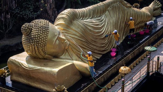 TOPSHOT - Workers clean a Buddha statue at Maha Vihara Mojopahit temple in Mojokerto on May 30, 2023, ahead of the Vesak festival which commemorates the birth, enlightenment and death of Buddha. (Photo by JUNI KRISWANTO / AFP) (Photo by JUNI KRISWANTO/AFP via Getty Images)