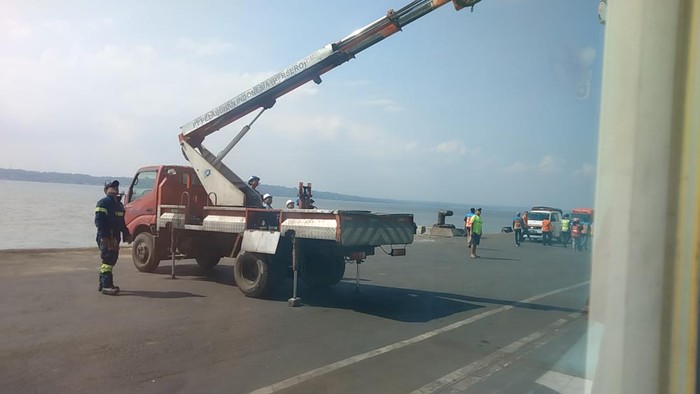 Evakuasi pria berdiri di atap terminal penumpang pelabuhan Tanjung Perak.