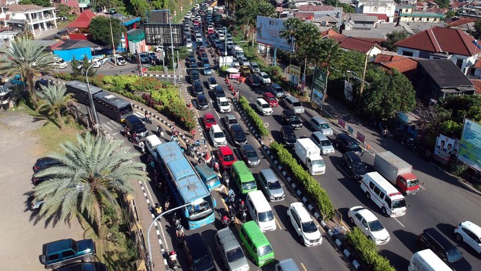 Foto udara kepadatan kendaraan saat diberlakukan rekayasa lalu lintas sistem satu arah di jalur wisata Puncak,Simpang Gadog, Ciawi, Kabupaten Bogor, Jawa Barat, Kamis (1/6/2023). Kepadatan kendaraan menuju kawasan wisata Puncak Bogor disebabkan oleh tingginya antusias warga memanfaatkan libur panjang cuti bersama Hari Lahir Pancasila serta libur Hari Raya Waisak  untuk berwisata, dan Sat Lantas Polres Bogor memberlakukan sistem satu arah (one way) untuk mengurai kepadatan kendaraan. ANTARA FOTO/Yulius Satria Wijaya/aww.