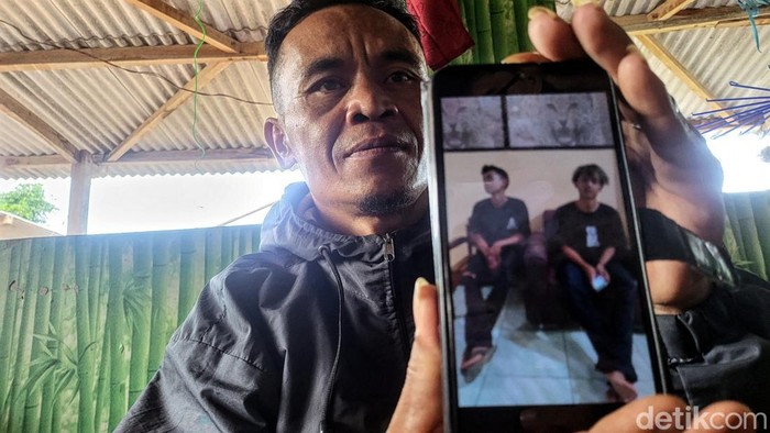 Aben (32) menunjukan foto dua putranya yang diamankan di Polres Sukabumi