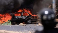 Sebuah mobil terbakar saat bentrokan antara pasukan keamanan dan mahasiswa serta pendukung pemimpin oposisi Senegal Ousmane Sonko, setelah Sonko dijatuhi hukuman penjara di Dakar, Senegal 1 Juni 2023. 