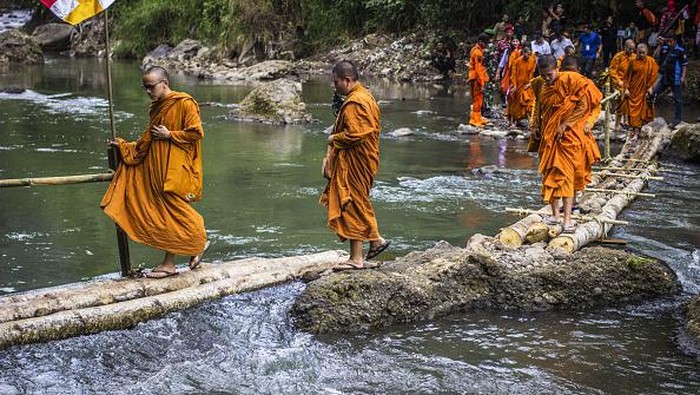 SEMARANG, INDONESIA - MAY 29: Buddhist monks cross the wooden footbridge on the Kaligarang River during a religious journey (International Thudong) in Semarang, Central Java, Indonesia on May 29, 2023. 32 monks from Thailand started their journey of more than 2000 km from a monastery in Nakhon Sri Thammarat Province, Thailand at the end of March to Borobudur Temple located in central Java, Indonesia to welcome Vesak which falls on Sunday, 4 June 2023. Before arriving in Indonesia, the monks passed through several countries, such as Malaysia and Singapore. Thudong is a ritual journey of the monks who walk thousands of kilometers to train their patience. (Photo by WF Sihardian/Anadolu Agency via Getty Images)