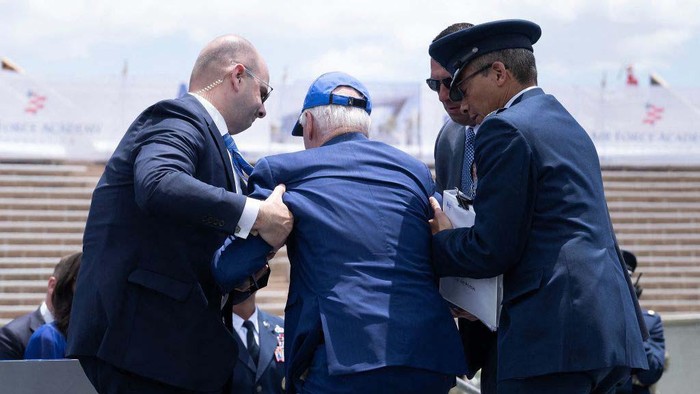 Detik-detik Joe Biden Tersandung dan Jatuh Tersungkur di Acara Wisuda US President Joe Biden is helped up after falling during the graduation ceremony at the United States Air Force Academy, just north of Colorado Springs in El Paso County, Colorado, on June 1, 2023. (Photo by Brendan Smialowski / AFP) (Photo by BRENDAN SMIALOWSKI/AFP via Getty Images)