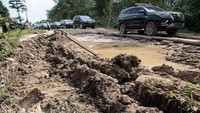 Iring-iringan kendaraan melaju pelan saat melintasi jalan rusak di Kec Cengal, Kabupaten Ogan Komering Ilir (OKI), Sumatera Selatan, Jumat (2/6/2023).  