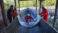 Pengajar Teknik Perkapalan Institut Teknologi Sepuluh Nopember (ITS) memberikan arahan warga dalam mempersiapkan cetakan kapal long boat berbahan fiber di galangan kapal bantuan dari Kementerian Sosial di Distrik Agats, Kabupaten Asmat, Papua Selatan, Jumat (2/6/2023).  