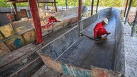 Sejumlah warga membersihkan cetakan kapal long boat berbahan fiber di galangan kapal bantuan dari Kementerian Sosial di Distrik Agats, Kabupaten Asmat, Papua Selatan, Jumat (2/6/2023).  