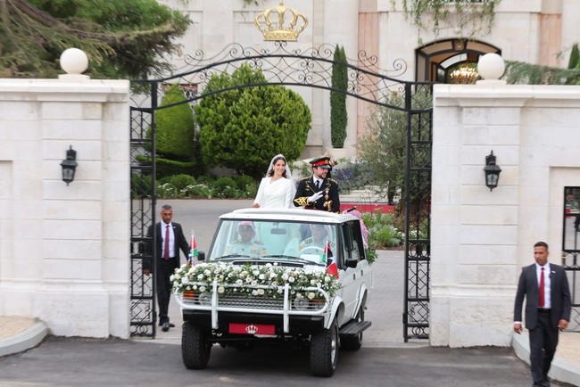 Setelah prosesi akad nikah, Pangeran Hussein dan istrinya Rajwa Al Saif naik mobil jip melakukan pawai untuk menyapa warga yang sudah berkumpul di luar Istana Zahran, Amman, Yordania. Foto: Dok. Getty Images, Instagram Queen Rania