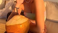 Kali ini ‘pacar baru’ Okin itu sedang mencoba air kelapa segar di kafe The Lawn Canggu, Bali. Foto: Instagram @reginaaphx
