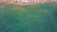 Warga memadati pantai untuk mendinginkan badan saat cuaca panas.