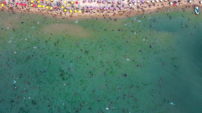 An aerial view shows Palestinians gathering on the beach in Gaza City on June 2, 2023, during a heat wave. (Photo by MOHAMMED ABED / AFP) (Photo by MOHAMMED ABED/AFP via Getty Images)
