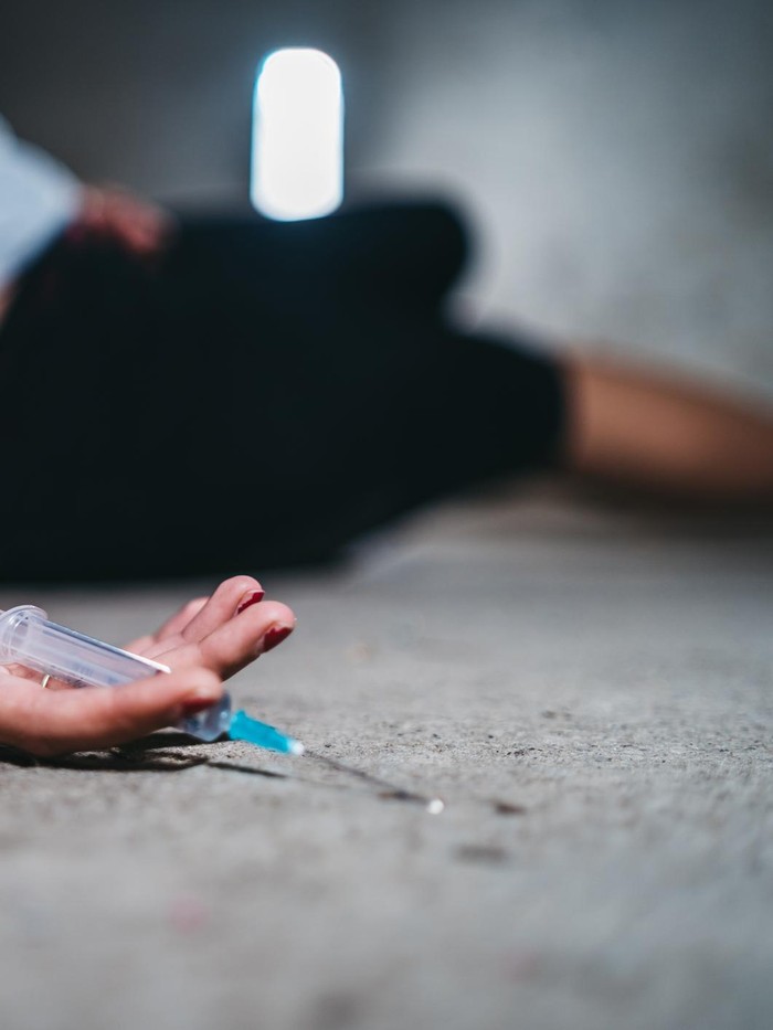Young caucasian woman passed out after overdosed herself.
