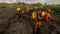 Petugas Badan Penanggulangan Bencana Daerah (BPDB) Provinsi Kalsel memanggul peralatan usai memadamkan kebakaran lahan di beberapa titik.