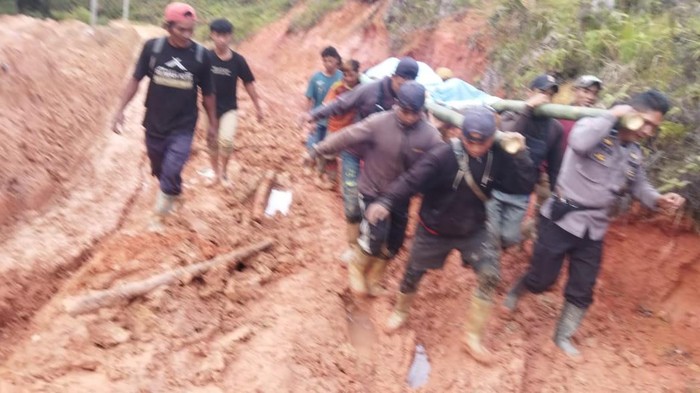 Warga bersama polisi menandu jasad tukang ojek melewati jalan rusak di Seko, Luwu Utara, Sulsel.