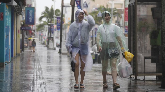 Dampak Topan Mawar di Jepang Women walk down the famed