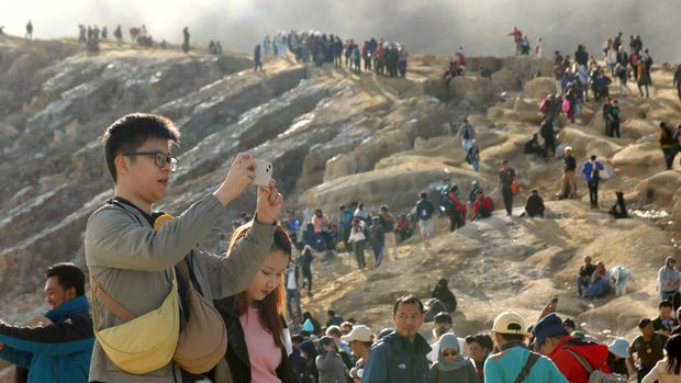Pengunjung melihat kawah dari kaldera Gunung Ijen di Banyuwangi, Jawa Timur, Minggu (4/5/2023). TWA Ijen yang telah ditetapkan sebagai anggota UNESCO Global Geopark (UGG) itu ramai dikunjungi wisatawan domestik dan mancanegara saat liburan. ANTARA FOTO/Budi Candra Setya/tom.