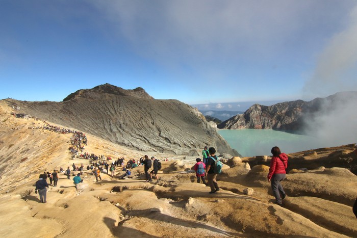 Pengunjung melihat kawah dari kaldera Gunung Ijen di Banyuwangi, Jawa Timur, Minggu (4/5/2023). TWA Ijen yang telah ditetapkan sebagai anggota UNESCO Global Geopark (UGG) itu ramai dikunjungi wisatawan domestik dan mancanegara saat liburan. ANTARA FOTO/Budi Candra Setya/tom.