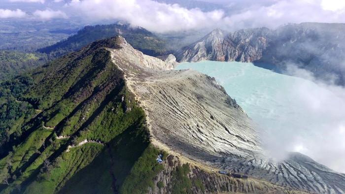 Pengunjung melihat kawah dari kaldera Gunung Ijen di Banyuwangi, Jawa Timur, Minggu (4/5/2023). TWA Ijen yang telah ditetapkan sebagai anggota UNESCO Global Geopark (UGG) itu ramai dikunjungi wisatawan domestik dan mancanegara saat liburan. ANTARA FOTO/Budi Candra Setya/tom.